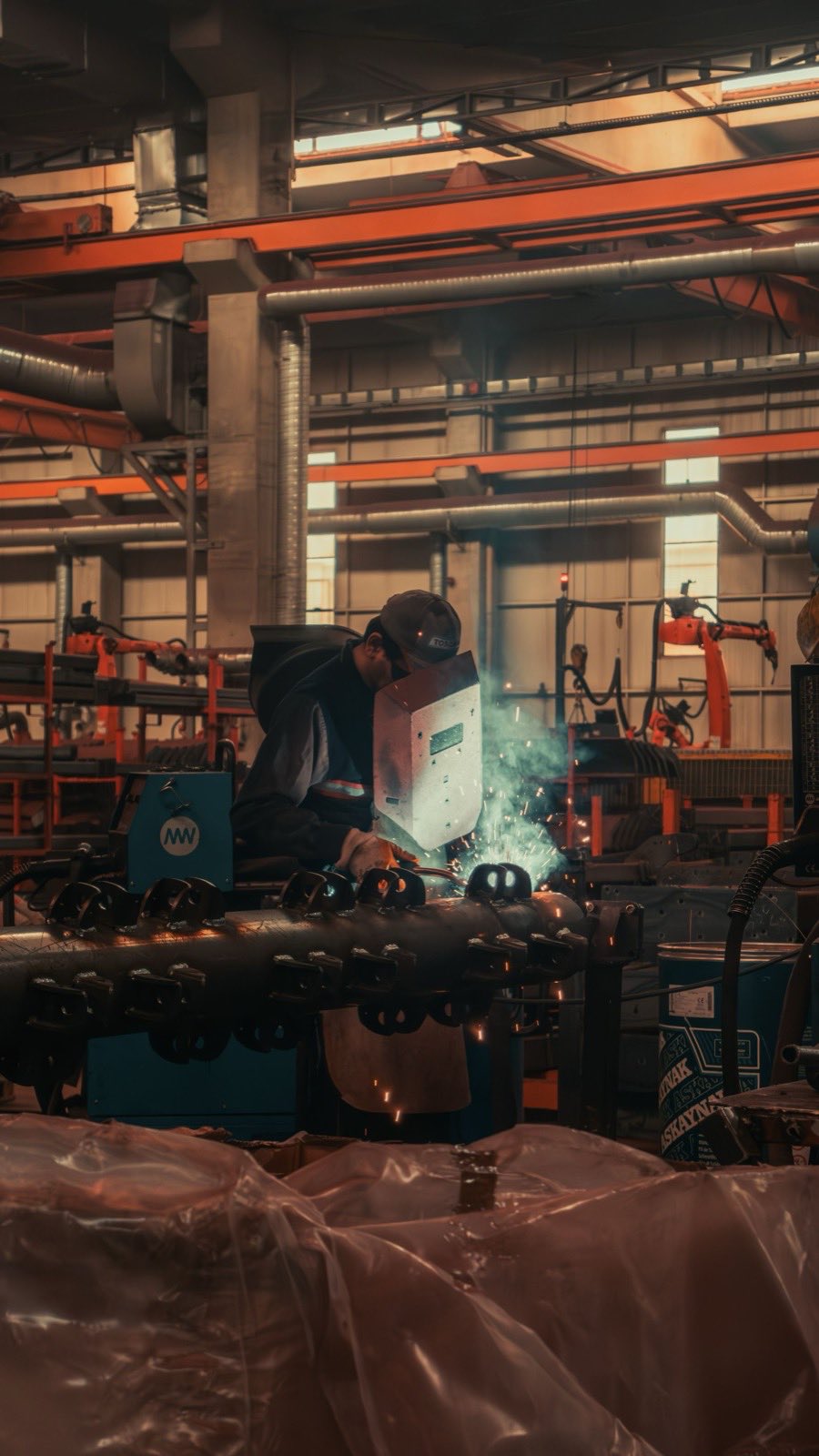 A welder at work in an industrial factory setting